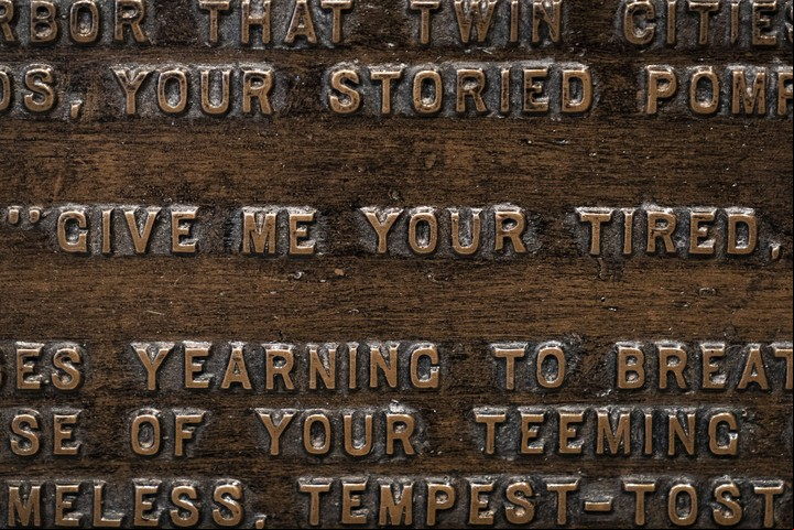 La placa de bronce en la base de la Estatua de la Libertad donde está inscripto el soneto "El nuevo coloso", de la poeta Emma Lazarus. / AFP