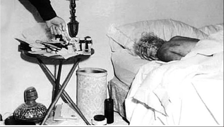 El brazo de un hombre señalando las pastillas que habrían provocado la muerte de la actriz, en agosto de 1962. Sería el policía Jack Clemmons, inspector de la comisaría de Los Ángeles, quien recibió el llamado que anunciaba la muerte de Marilyn (Captura de video).