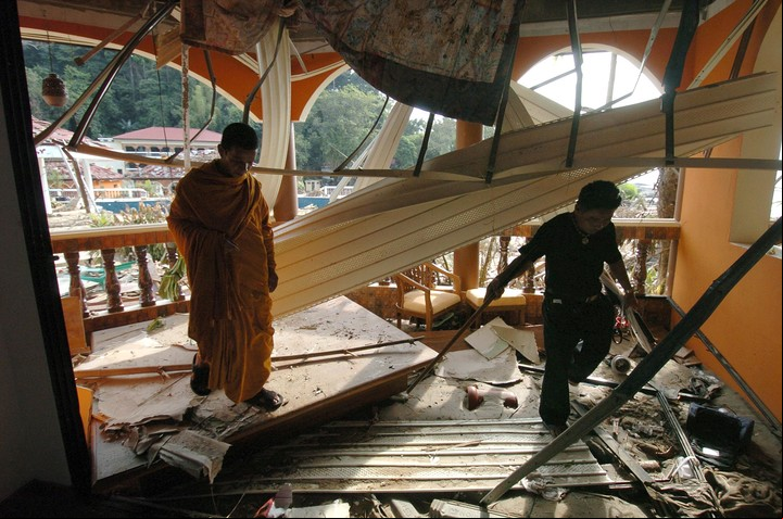 Monjes budistas buscan cuerpos en hotel Similan Beach y Spa Resort, en Phuket./ AFP