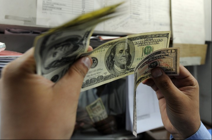 Observar los billetes a contraluz es una de las precauciones más conocidas, pero hay muchas otras. Foto: AFP.