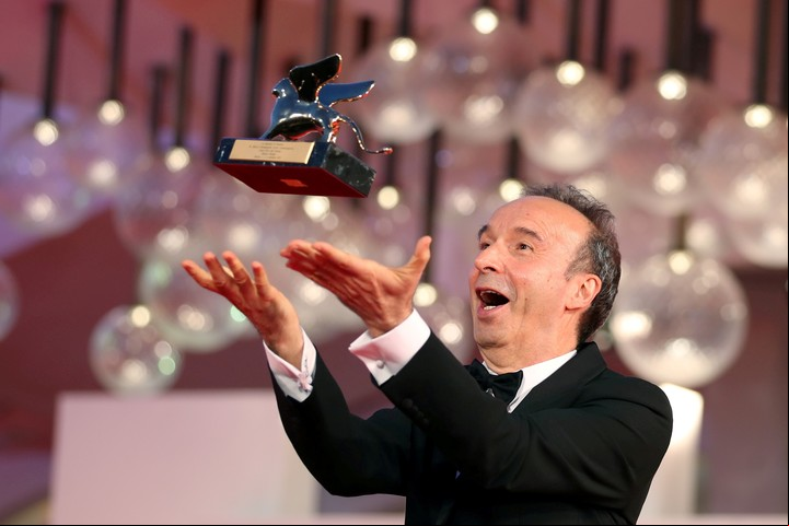 Roberto Benigni juega con su León de Oro a la trayectoria. Foto Reuters