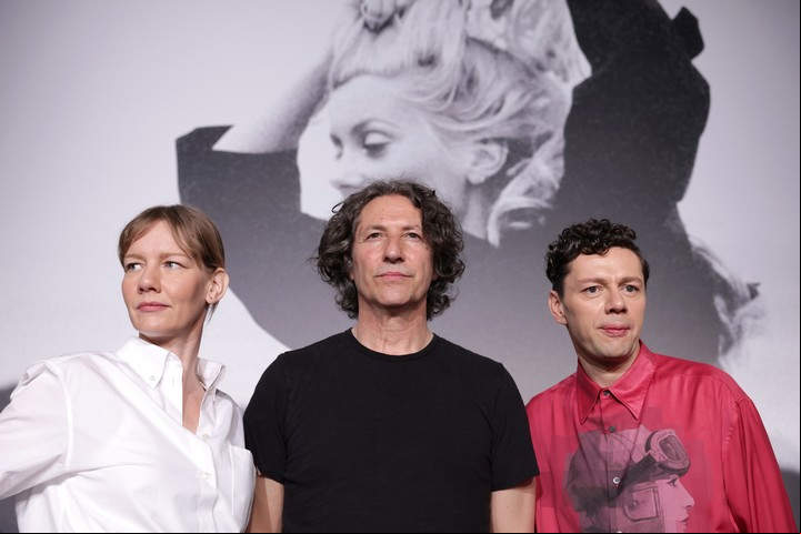 Los actores Sandra Hueller y Christian Friedel, el matrimonio nazi, rodean al director Jonathan Glazer. Foto EFE