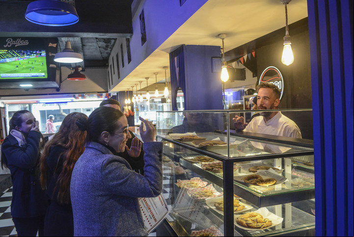 René, uno de los dueños, explica cómo son los pretzels a un grupo de visitantes. Fotos Constanza Niscovolos