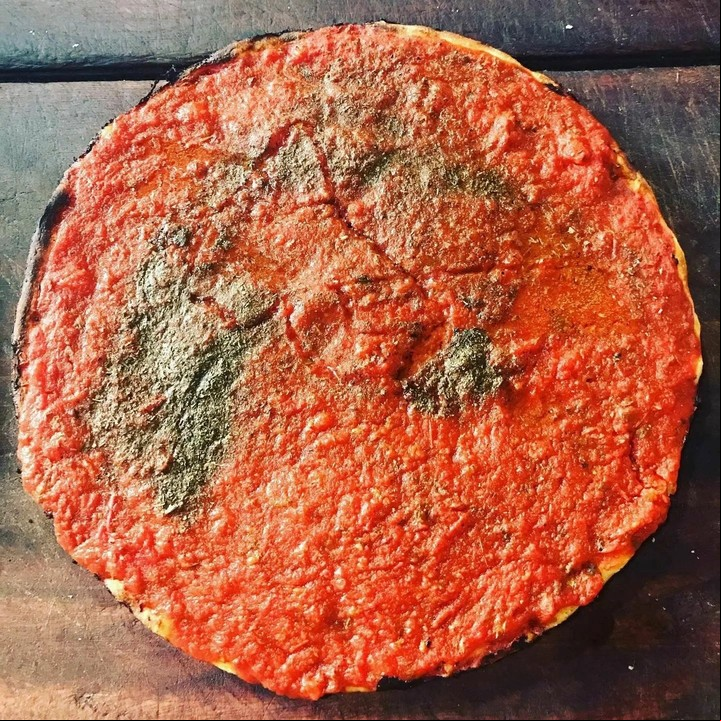 La pizza canchera, un clásico de Angelín, se distingue por su masa fina, mucha salsa de tomate y especias, todo sin muzzarella. Foto: Instagram @angelin.pizzeria.