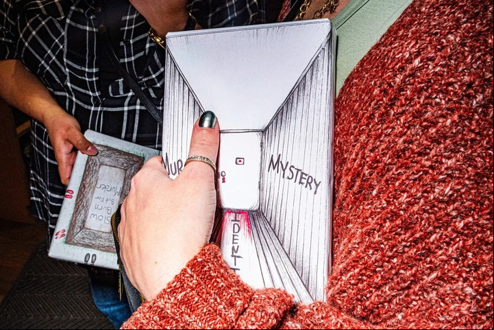 Jylian Polson, una turista de Portland, sostiene la cita a ciegas con un libro que planea comprar, titulado "Identity Murder Mystery" (Misterio de asesinato de identidad). Foto: Emma Rose Milligan para The New York Times.