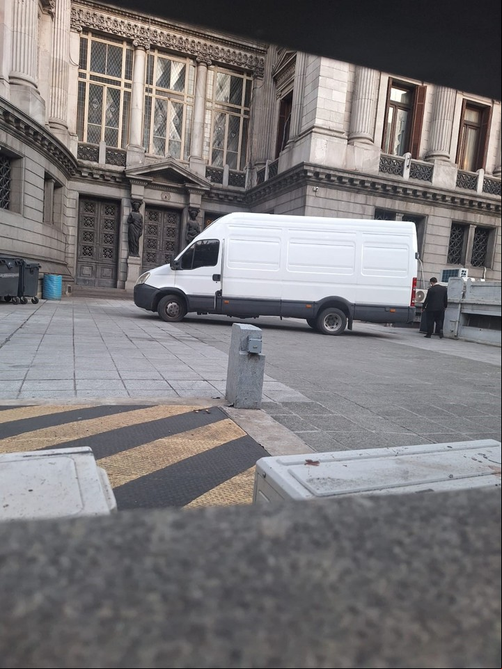 Una camioneta blanca está estacionada dentro del estacionamiento interno del Senado.