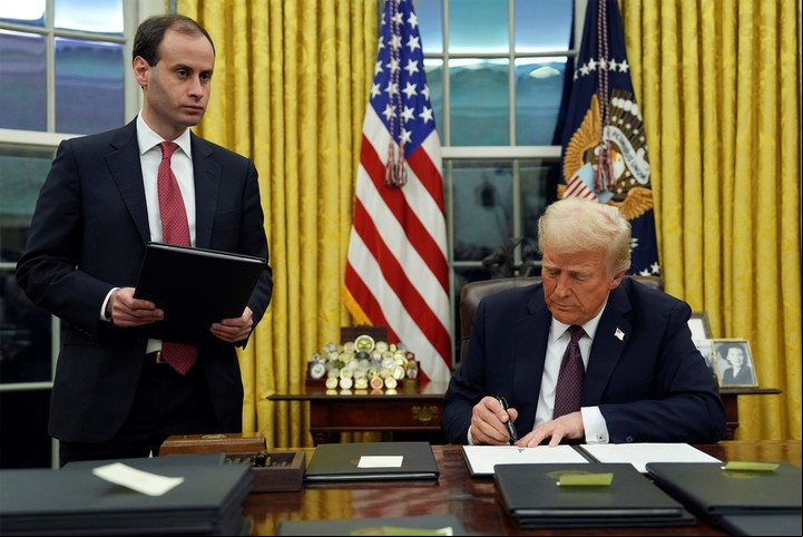 El presidente Donald Trump firma una orden ejecutiva para crear el Departamento de Eficiencia Gubernamental (DOGE) en el Despacho Oval de la Casa Blanca, el lunes 20 de enero de 2025, en Washington, mientras el secretario de personal de la Casa Blanca, Will Scharf, observa. (AP Photo/Evan Vucci)