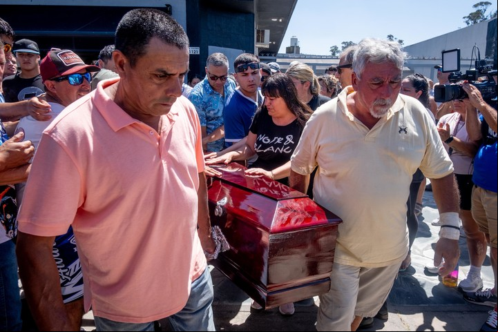 Horacio Paredes, de remera amarilla, carga el ferétro con el cuerpo de su hija Matías, asesinado por policías de civil en Mar del Plata. Foto: Diego Izquierdo