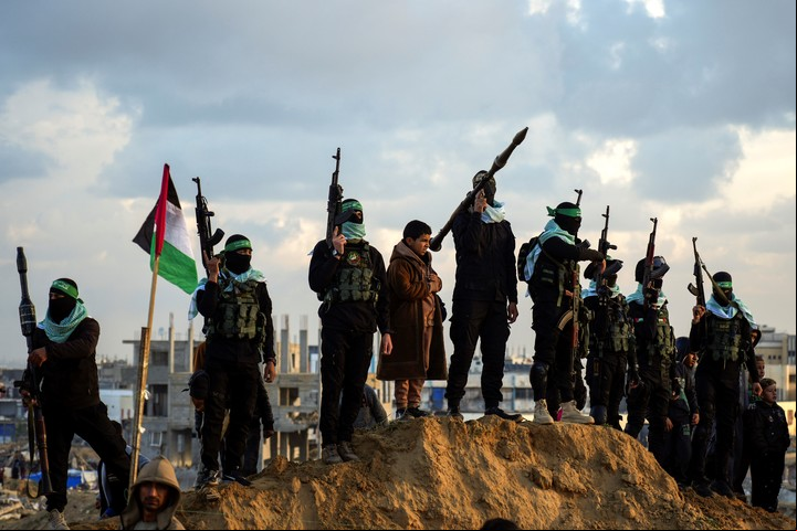 Los terroristas de Hamas, en una siniestra puesta en escena tras la entrega de los ataúdes con los cuatro rehenes, este jueves. Foto: AP