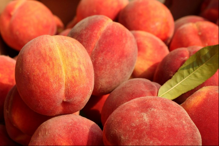 Rico en vitamina A y C, el durazno ayuda a reparar los tejidos dañados por la exposición solar. Foto: Unsplash.