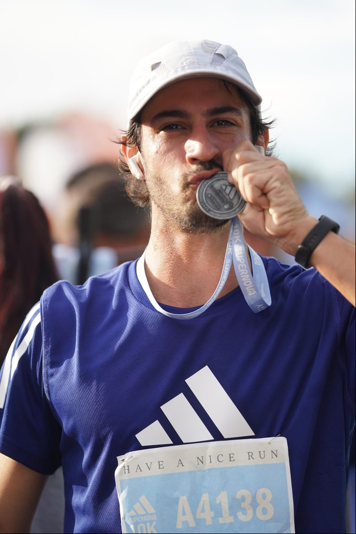 Un particante, feliz con su medalla de finisher.