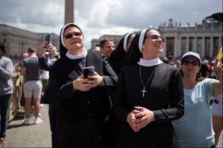 Monjas en la plaza miran la chimenea. Foto: Reuters