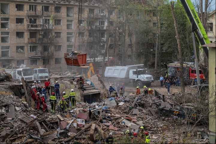 Trabajadores de emergencias buscan a personas sepultadas bajo los escombros de un edificio de apartamentos destruido por un ataque con misiles rusos en Kiev en abril. Foto Brendan Hoffman para The New York Times