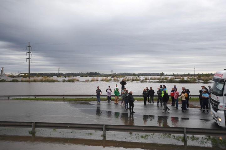 AME8824. CAMPANA (ARGENTINA), 17/05/2025.- Varias personas conversan en una calle inundada este sábado, en Campana, Buenos Aires (Argentina). Unas 2.800 personas fueron evacuadas este sábado en la zona norte y oeste de la provincia de Buenos Aires, en medio del temporal de tres días de lluvias quse afectó 30 distritos bonaerenses, según informaron fuentes oficiales. EFE/ STR